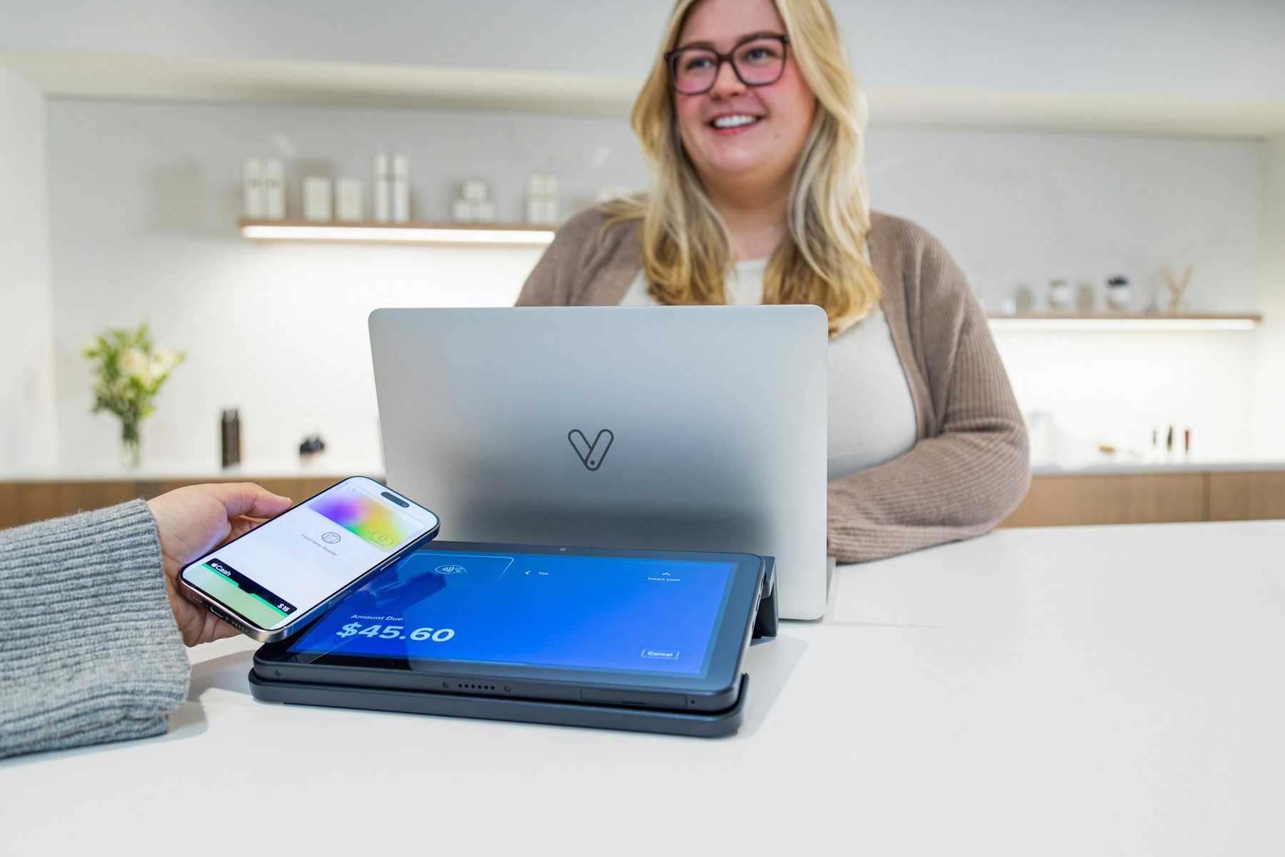 Customer using tap to pay at a local business front desk